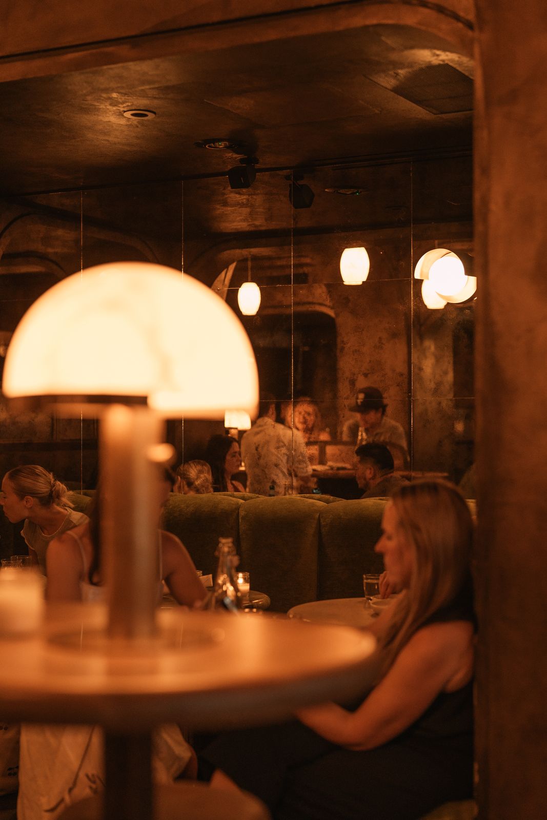 Moody dining room with dome lamps and mirrored walls