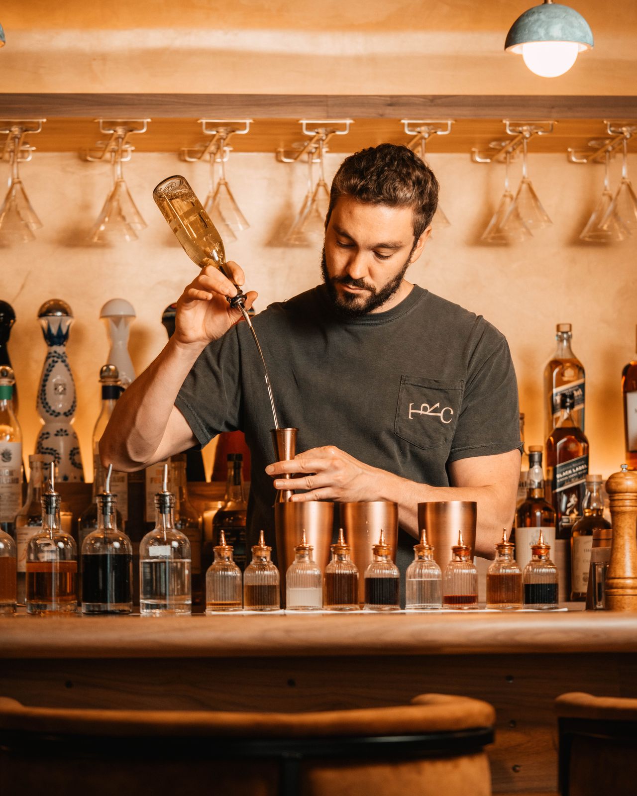 Bartender pouring a cocktail garnish at The Rhymers' Club bar