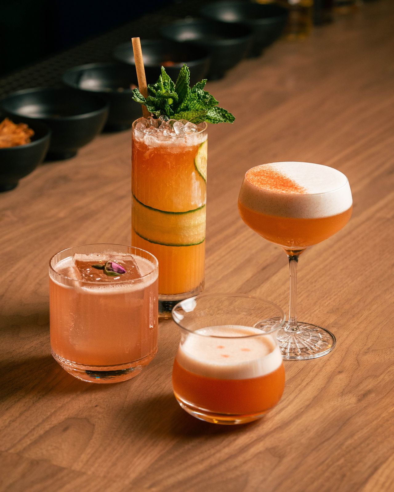 Four garnished cocktails on the bar